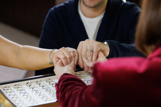 Couple try on wedding rings with the help of James Porter & Son employee